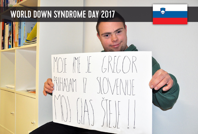 Male Slovenian youth with DS holding a sign in his hands with his statement for WDSD 2017