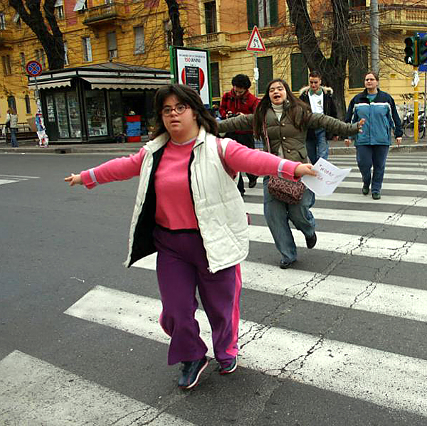 Young women with Down syndrome on a pedestrian crosswalk, spreading her arms