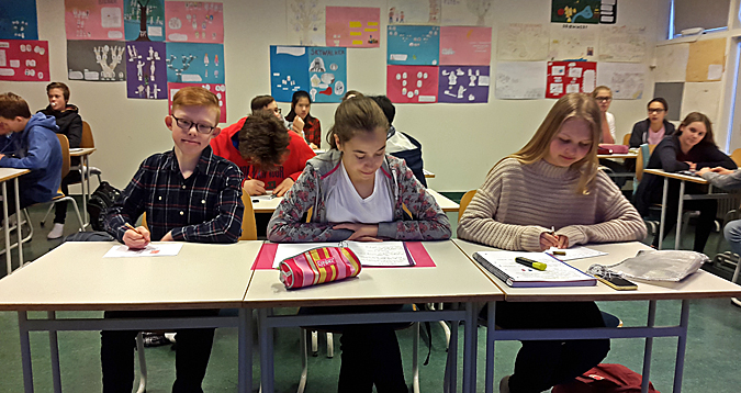 Finnbogi Örn in his classroom, sitting at his desk with his classmates around
