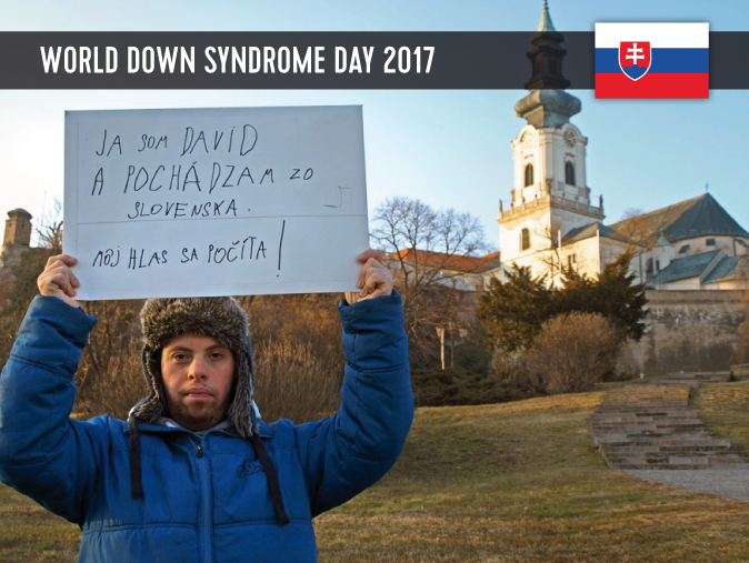 A male youth with Down Syndrome showing a sign with his statement