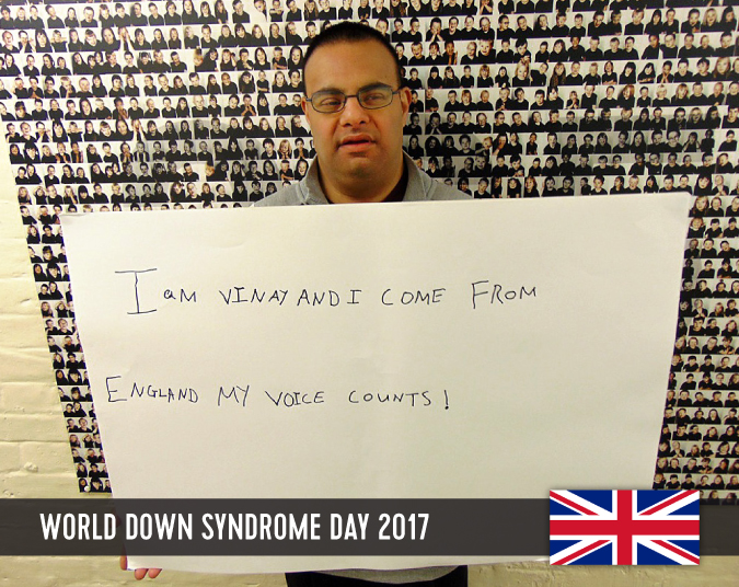 Young man with Down syndrome holding a sign in front of him with his statement to WDSD 2017.