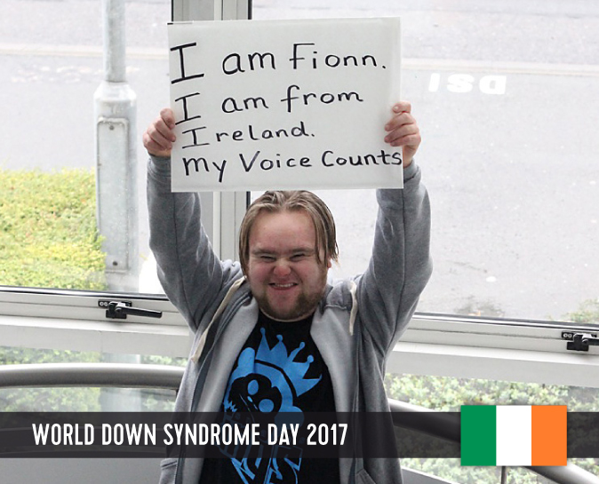 Young man with Down syndrome holding a sign above his head with his statement to WDSD 2017