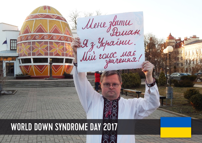 Young man with Down syndrome holding a sign above his head with his statement to WDSD 2017.