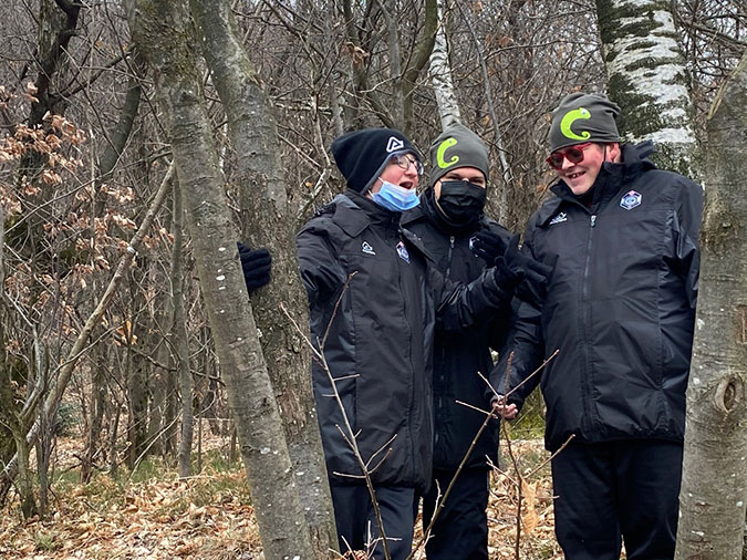 Three members of the Chameleon football team in the forest