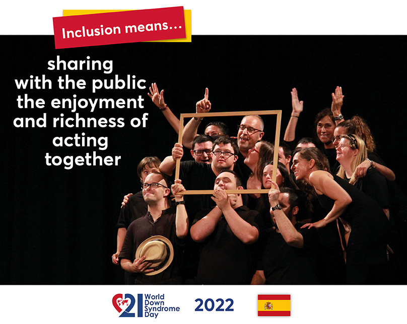 The picture shows members of an inclusive theatre group. One of them is holding a picture frame for a joint photo. Many of them try to get their heads into the picture within the frame.