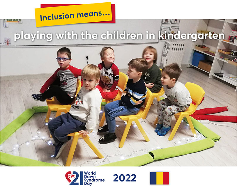 Rolled-up cloths on the floor of a kindergarten form the outline of a boat. In this "boat" six kindergarten children are sitting on chairs and visibly having fun.