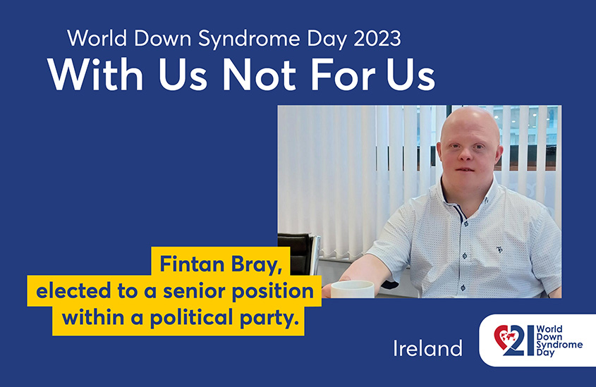 Poster of the 2023 EDSA WDSD Poster campaign “With Us Not For Us”. The photo shows Fintan Bray in a white shirt sitting at his desk. Text to the photo shown: Fintan Bray, elected to a senior position within a political party.