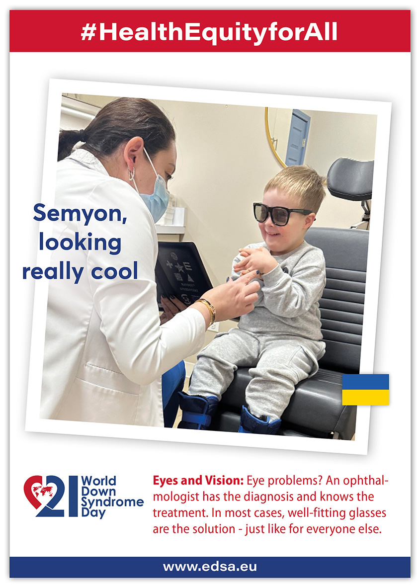 A young boy with DS sits in front of an ophthalmologist who is examining him. He is wearing special dark glasses.
